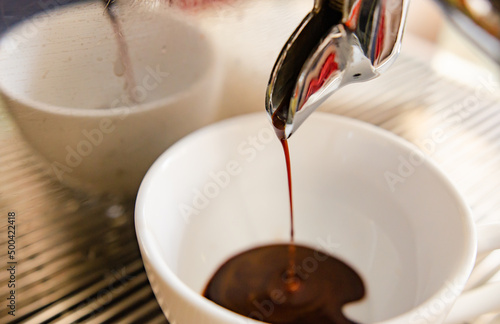 Espresso flowing from a fresh coffee machine, soft focus.