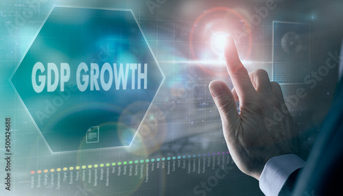 A businessman controlling a futuristic display with a GDP Growth business concept on it.