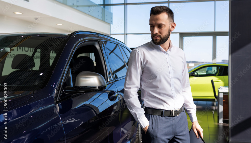 businessman in a car dealership looking for a new car businessman in a car dealership looking for a new car