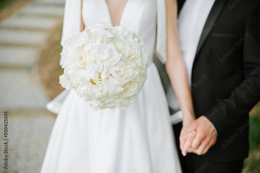 Bride holding beautiful white wedding bouquet. Closeup Bride holding beautiful white wedding bouquet. Closeup