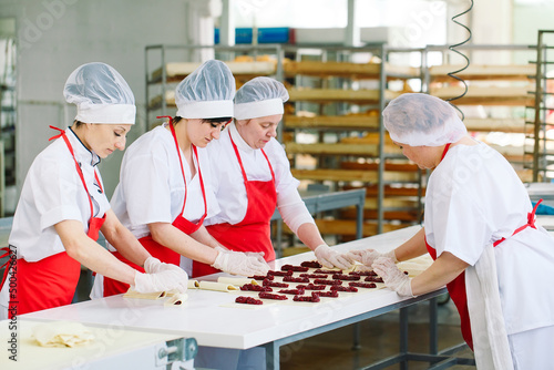 Workers of the confectionery factory prepare desserts with filling.