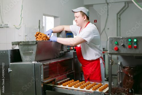 Cuadro en lienzo sweets production and industry concept - chocolate candies processing on conveyor at confectionery shop
