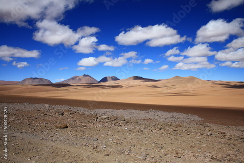 The landscape of the Atacama Desert in Chile, with clouds, volcano, lsand and salt.