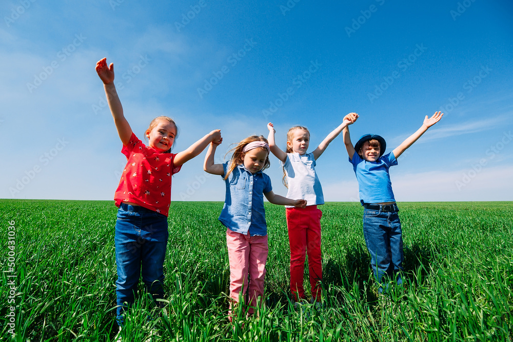 Happy Children on a green field with their hands up. Happy Children on a green field with their hands up.