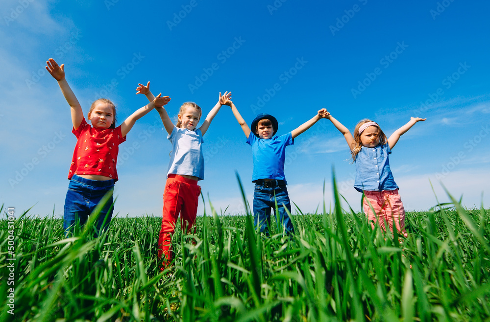 Happy Children on a green field with their hands up. Happy Children on a green field with their hands up.