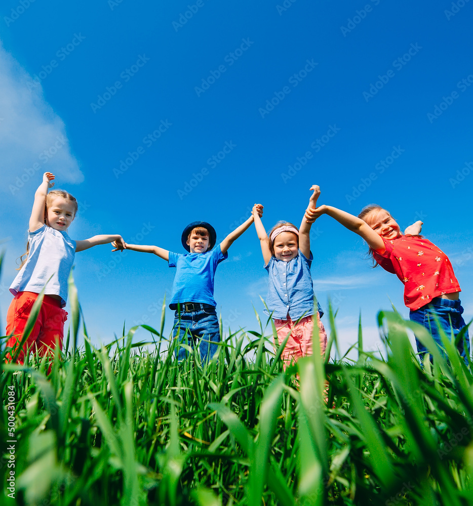 Happy Children on a green field with their hands up. Happy Children on a green field with their hands up.