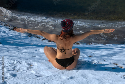 Fotografía Fit healthy ice woman back view body stretching and meditating on snow, cold exp