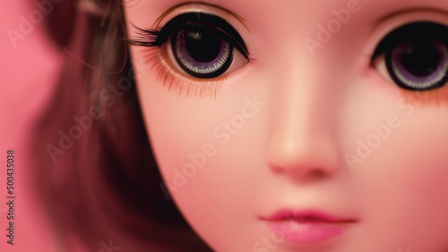 Beautiful doll. Close up. Portrait of attractive toy's face with big eyes.