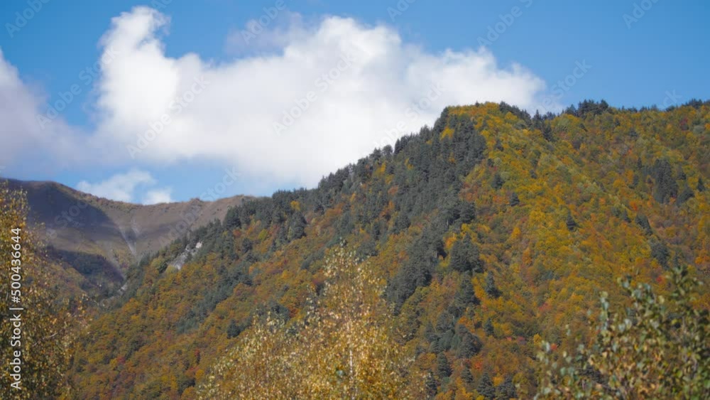 Beautiful landscape of sky, clouds and mountain covered in colorful trees in autumn. Slow motion. Beautiful landscape of sky, clouds and mountain covered in colorful trees in autumn. Slow motion.