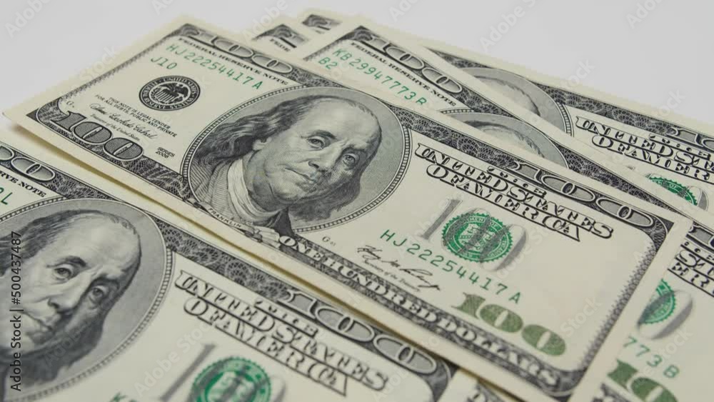 Green banknotes are throwing on the table close-up. The man quickly throws hundred dollar bills on the table. They are in one place. Good income Green banknotes are throwing on the table close-up. The man quickly throws hundred dollar bills on the table. They are in one place. Good income