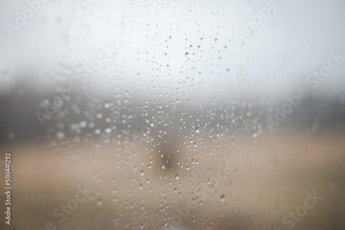 Natural pattern of rain drops on window glass surface.