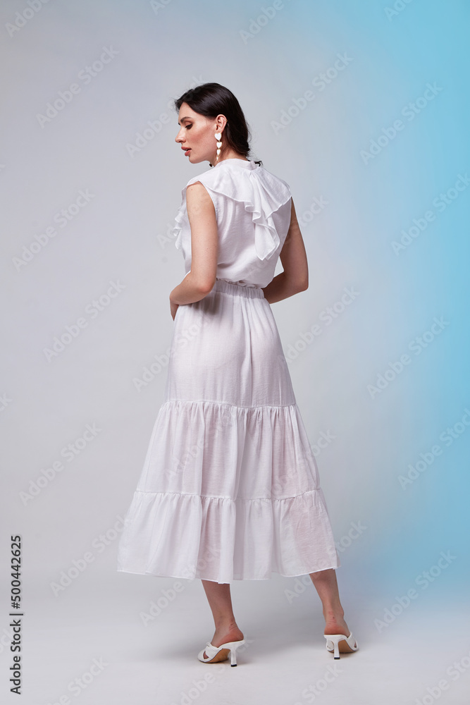 Beautiful woman fashion model makeup brunette hair perfect body shape tanned skin wear clothes summer collection organic long white silk dress stylish sandals shoes, accessory jewelry earrings date. Beautiful woman fashion model makeup brunette hair perfect body shape tanned skin wear clothes summer collection organic long white silk dress stylish sandals shoes, accessory jewelry earrings date.