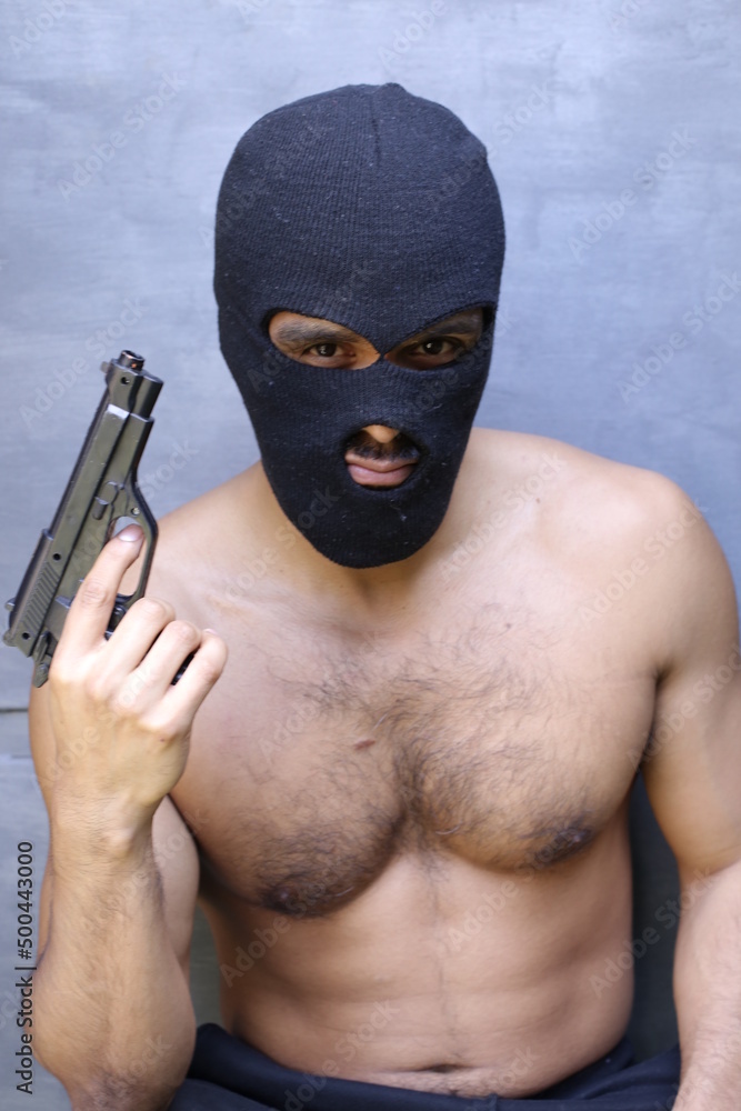 Shirtless muscular robber wearing just a balaclava Shirtless muscular robber wearing just a balaclava