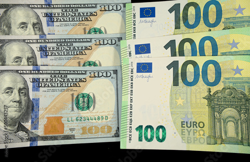 one hundred dollars and one hundred euro cash on black background
