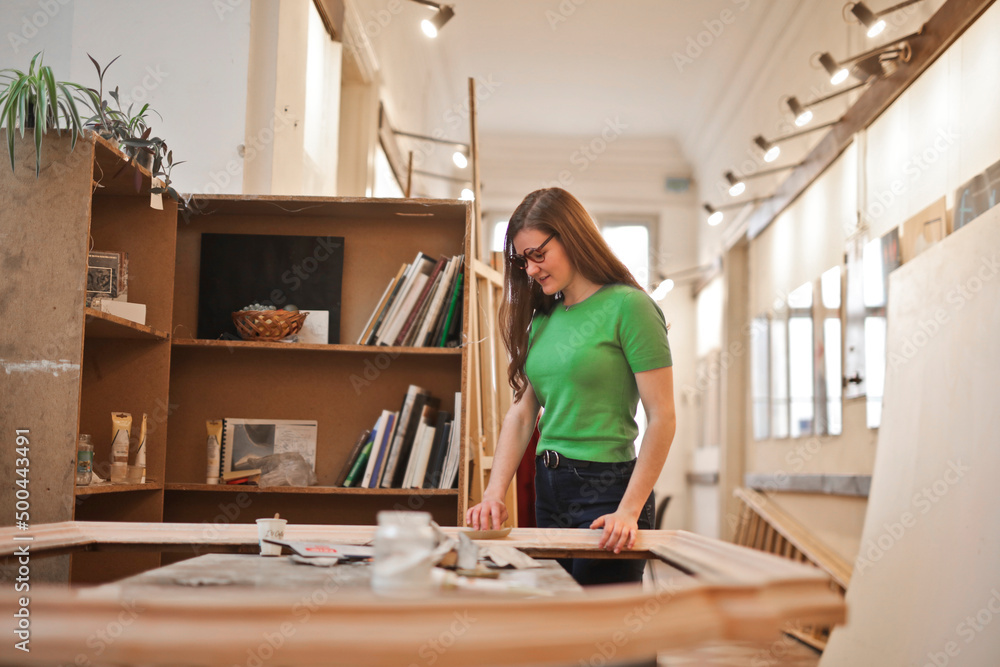 young woman works on a frame to be fixed young woman works on a frame to be fixed