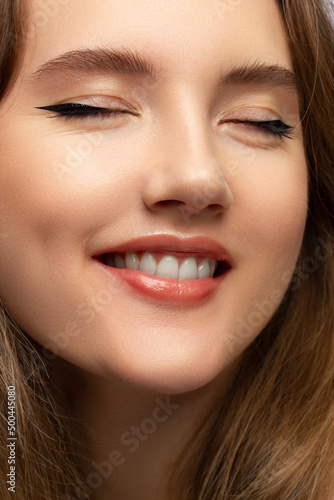 Close-up of woman's lips with fashion natural beige lipstick makeup. Macro sexy pale lipgloss make-up . Gentle pure skin and wavy blonde hair. Cosmetology, Spa, increase in lips