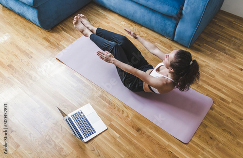 Woman building and toning abdomen muscles on exercise mat, workout fitness at home.