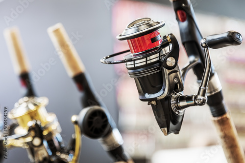 an assortment of fishing reels on the counter of a fishing shop