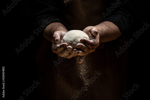 Clap hands of baker with flour. Beautiful and strong men's hands knead the dough make bread, pasta or pizza. Powdery flour flying into air