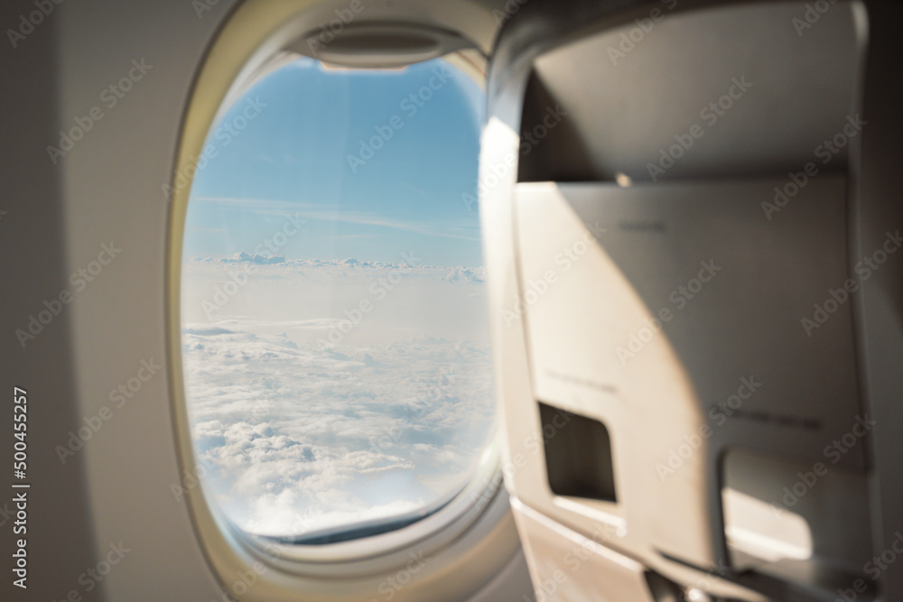 Plane window view with fluffy clouds look in the airplane.Blue sky and white clouds background.Fresh day and the weather is bright.Interior airplane.. Plane window view with fluffy clouds look in the airplane.Blue sky and white clouds background.Fresh day and the weather is bright.Interior airplane..