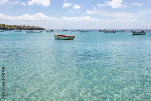 Small fishing boats on the crystal clear, turquoise waters at Playa Grandi (Playa Piscado) on the Caribbean island Curacao