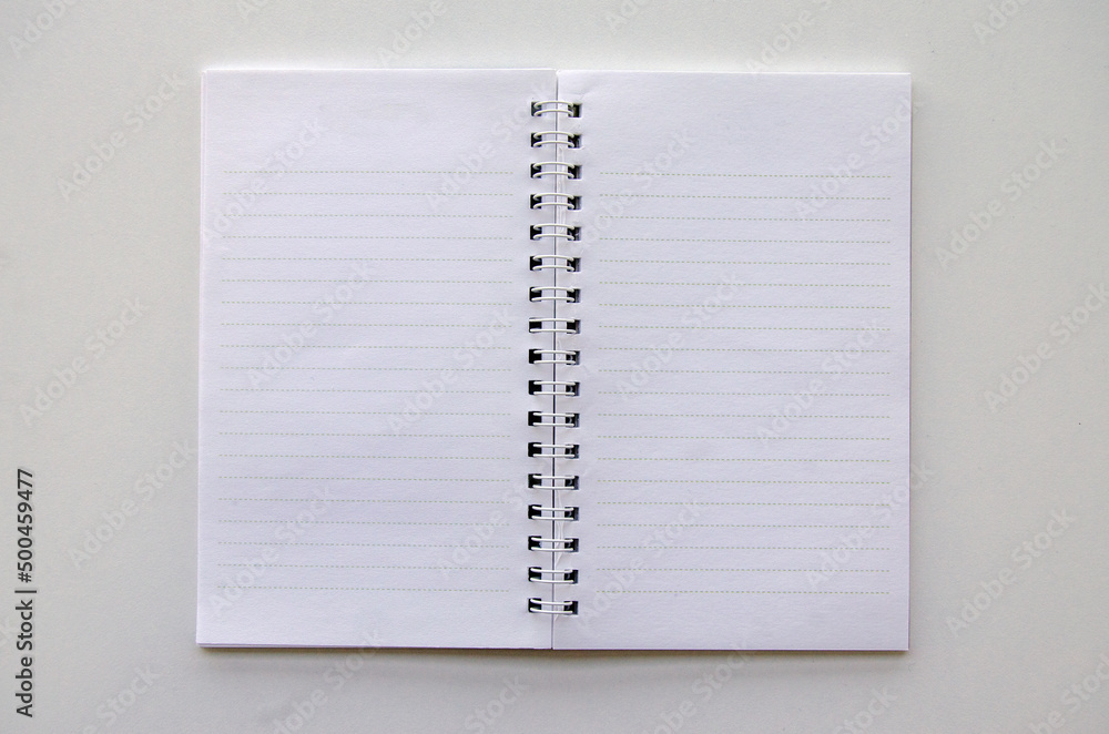 Top view isolated opened lined paper spiral small notepad on white background, office - education concept Top view isolated opened lined paper spiral small notepad on white background, office - education concept