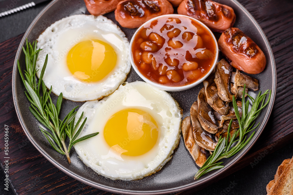 Full english breakfast with bean, fried eggs, roasted sausages, tomatoes and mushrooms Full english breakfast with bean, fried eggs, roasted sausages, tomatoes and mushrooms