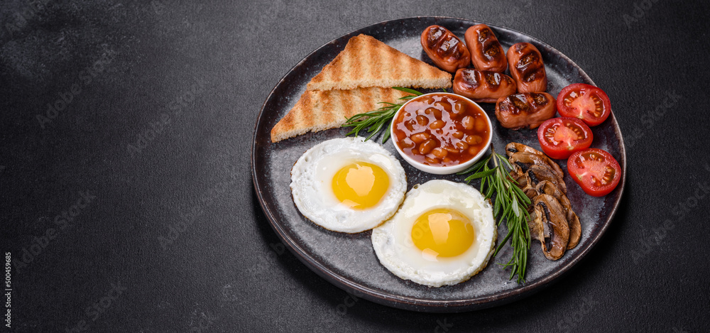 Full english breakfast with bean, fried eggs, roasted sausages, tomatoes and mushrooms Full english breakfast with bean, fried eggs, roasted sausages, tomatoes and mushrooms