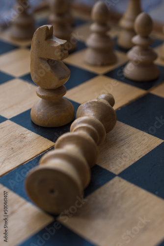 Chess board with figures. The concept of victory, the king is dead on the battlefield.