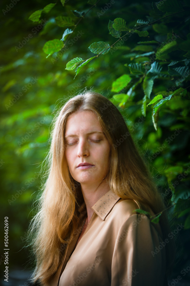 portrait of blond woman in nature with her eyes closed portrait of blond woman in nature with her eyes closed
