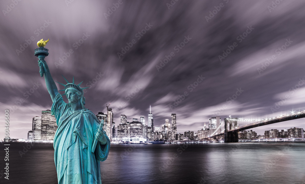 Fototapeta premium Manhattan panoramic skyline at night. New York City, USA. Statue of Liberty National Monument with skyscrapers background.