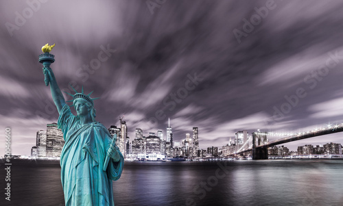 Manhattan panoramic skyline at night. New York City  USA. Statue of Liberty National Monument with skyscrapers background.