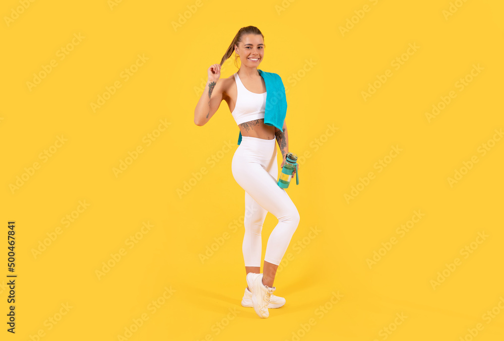 happy sport woman with water bottle on yellow background