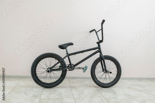 Fotografia a black bmx bike standing near the wall, extreme sports equipment