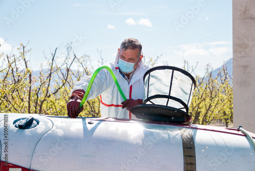 Farmer cleans a chemical spray tank after use
