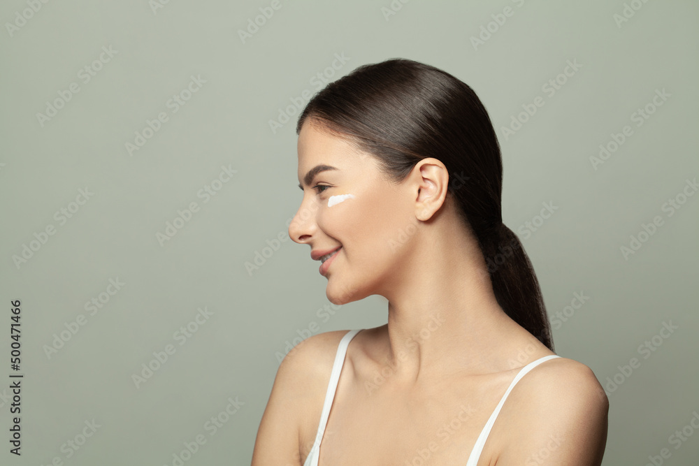 Beautiful profile of young healthy woman with moisture cream drops on her clean fresh skin. Facial treatment, beauty care and cosmetology concept Beautiful profile of young healthy woman with moisture cream drops on her clean fresh skin. Facial treatment, beauty care and cosmetology concept