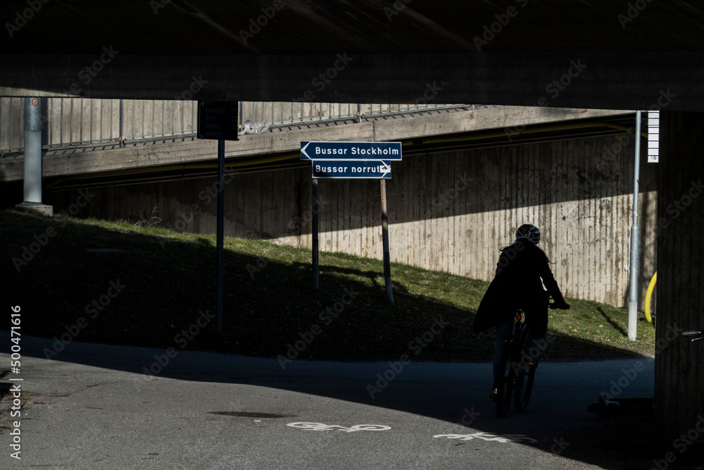 Stockholm, Sweden A bicyclist on a bike path in a tunnel with a Stockholm sign.