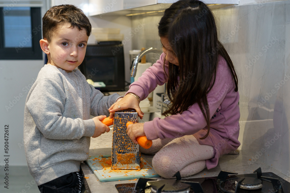 Bro Getting Cook Foto de Brother and sister cook in the kitchen together, grating ...