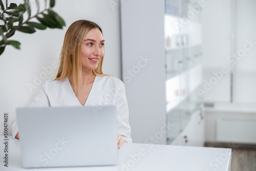 Εκτύπωση καμβά Joyful female cosmetologist using laptop in beauty salon