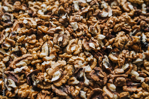 Background, texture of many walnuts, peeled nuts lying on the table. Food photography, top view.