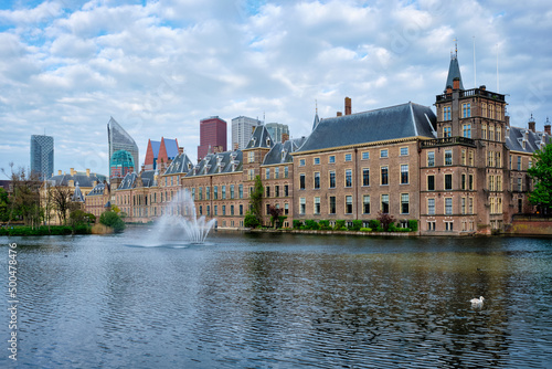 View of the Binnenhof House of Parliament and the Hofvijver lake with downtown skyscrapers in background. The Hague, Netherlands