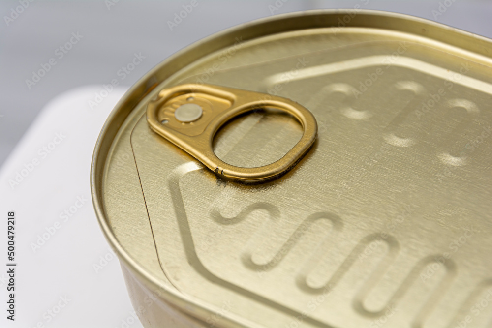 closed golden metal can close-up of a can with a key to open closed golden metal can close-up of a can with a key to open