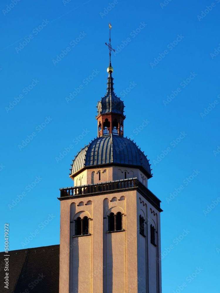 A church tower and at the end of the tower hangs a cross