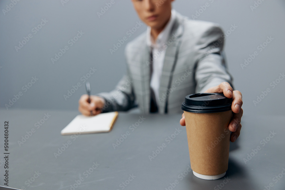 businessmen writes in a notebook sits on the table with coffee official executive businessmen writes in a notebook sits on the table with coffee official executive