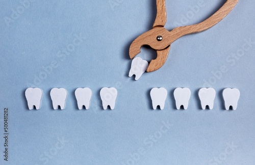 Surgical tooth extraction, removal procedure with forceps. Decayed root, gum diseases consequences. Dental health concept. Kids toy. High quality photo