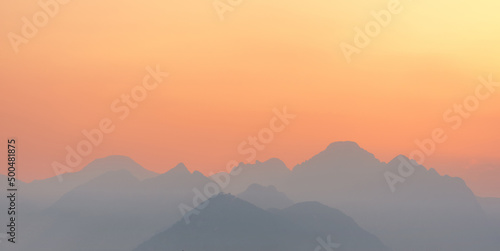 bright sunset or sunrise sky with misty mountains