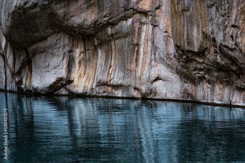 clean blue river with rocky banks at the bottom of a deep canyon