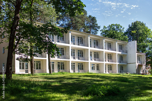 A typical three-story building of a sanatorium near Moscow with balconies on the river bank photo