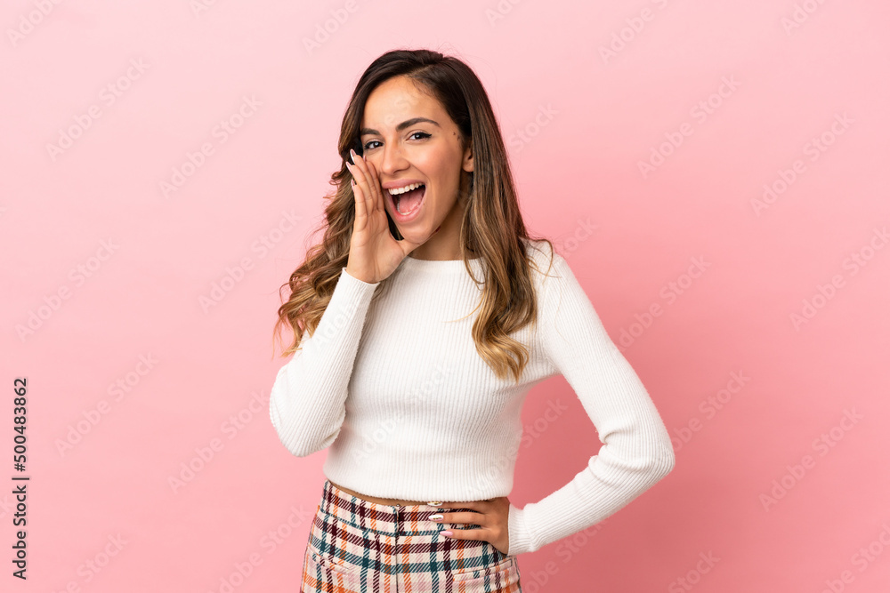 Young woman over isolated background shouting with mouth wide open Young woman over isolated background shouting with mouth wide open