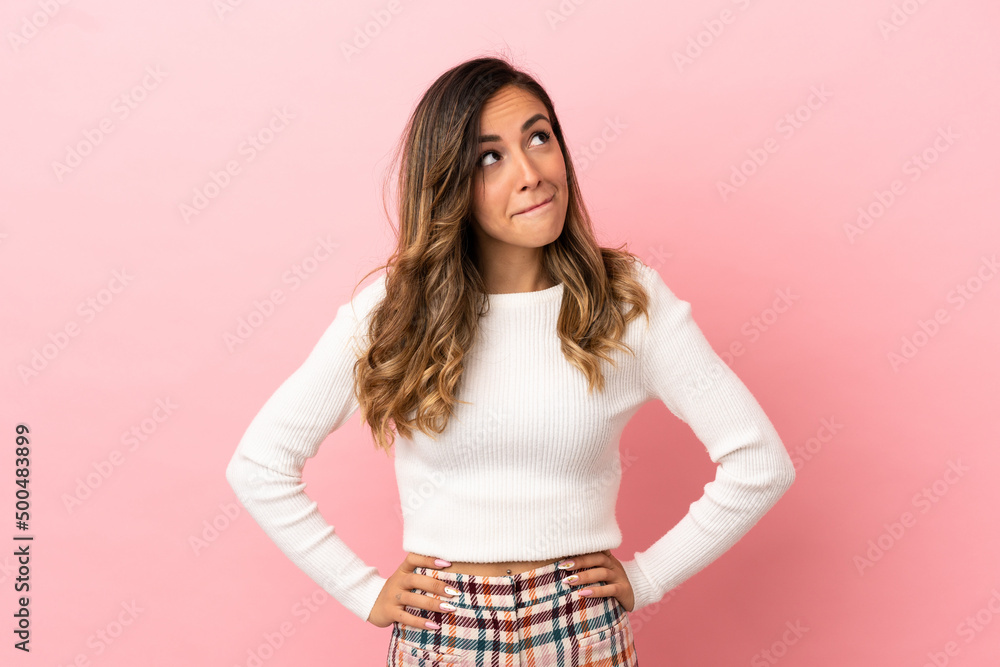 Young woman over isolated background having doubts while looking up Young woman over isolated background having doubts while looking up